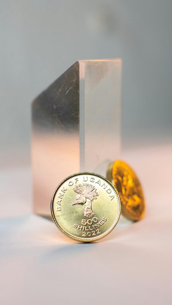 Detailed close-up of Ugandan shilling coins in a creative studio setting.
