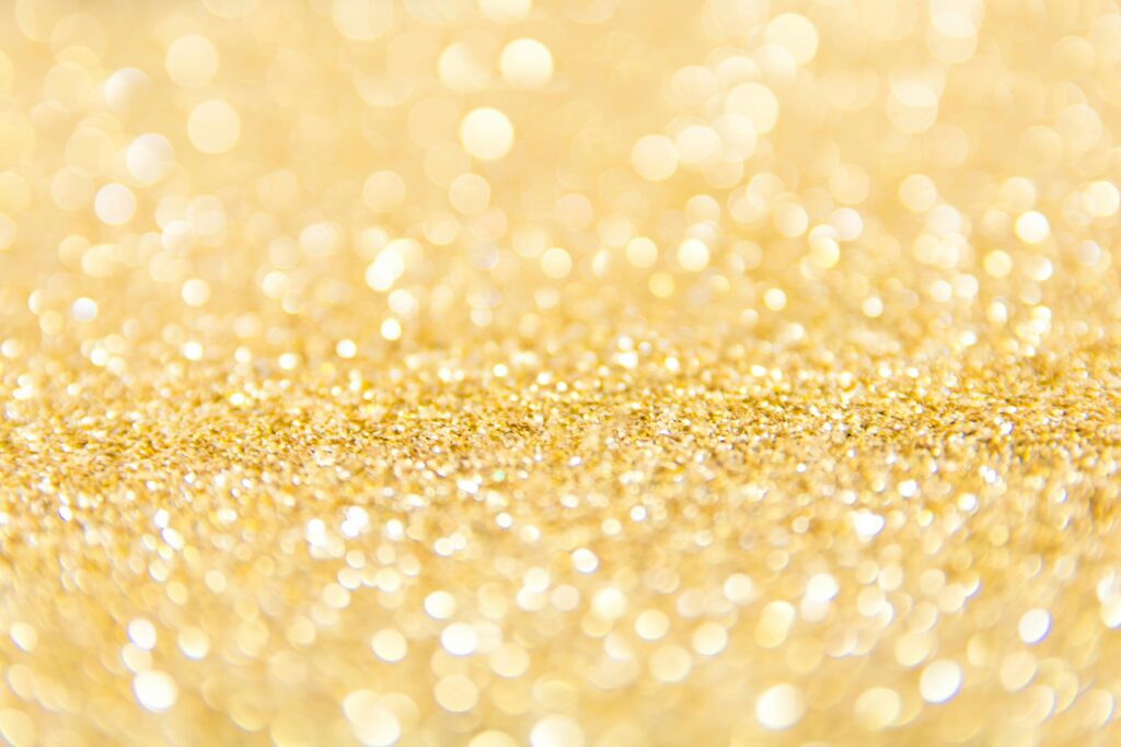 Abstract gold glitter background with a bokeh effect, ideal for festive designs.